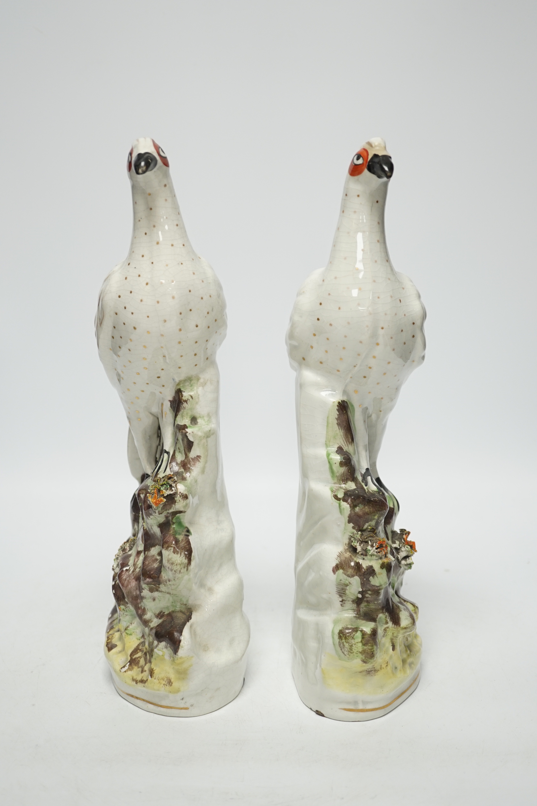 A pair of 19th century Staffordshire models of birds, each 32cm high